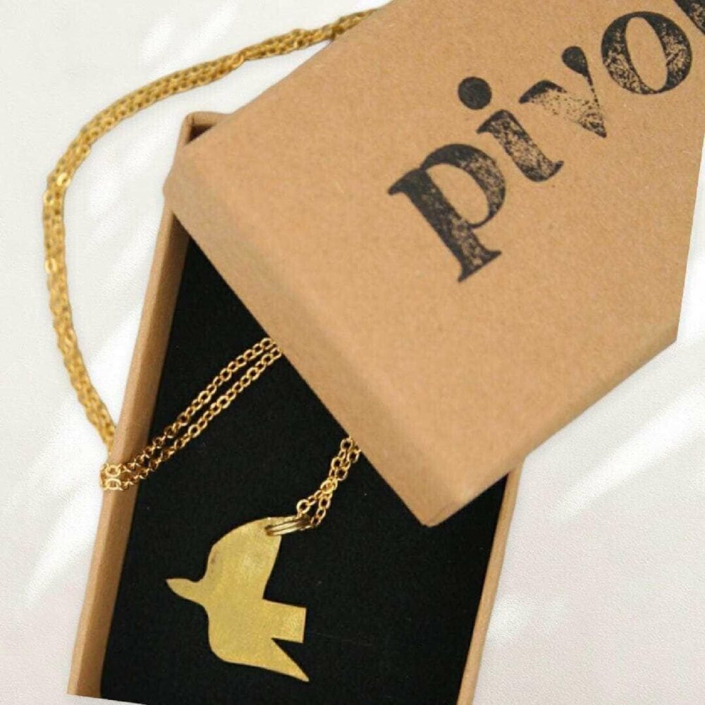 Pivot brass dove necklace shown in box
