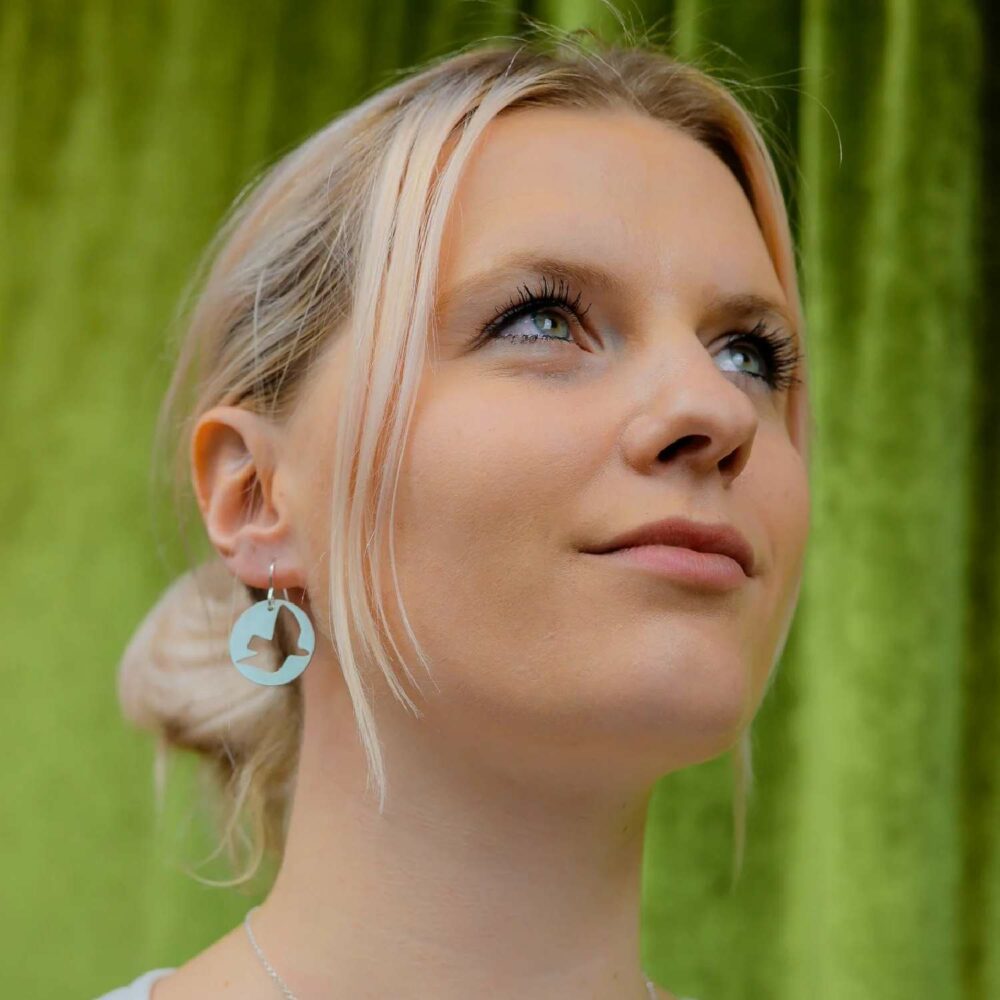 Woman wearing pivot silver dove disc earrings