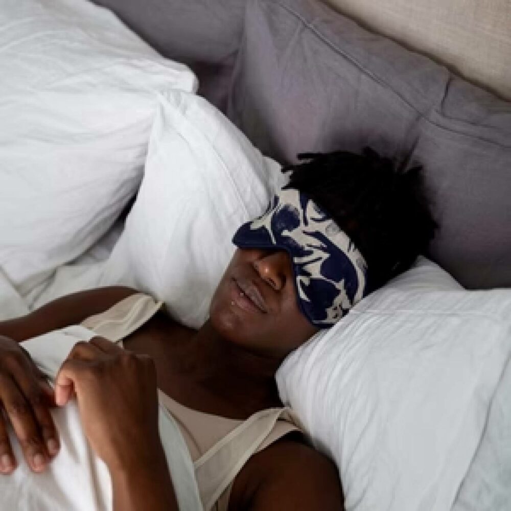 person lying in bed wearing blasta henriet eye mask