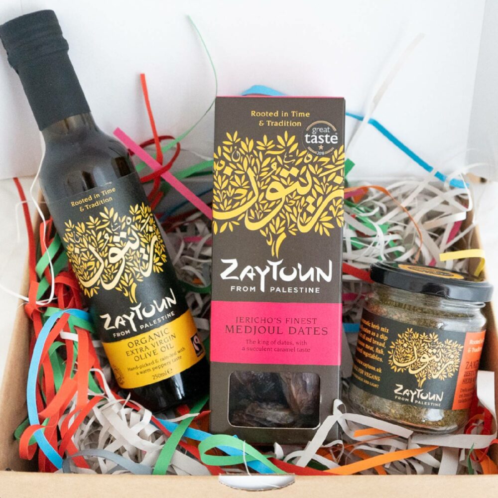 Open box showing bottle of olive oil, box of dates and jar of za'atar spice